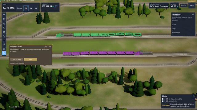 Purple and green trains on two parallel tracks running through a forested landscape.
